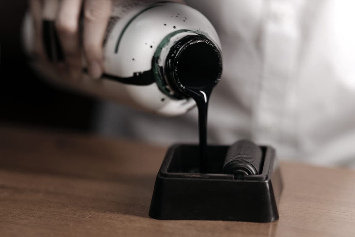 Ink being poured from a bottle, illustrating bottle-fed rather than cartridge-fed ink