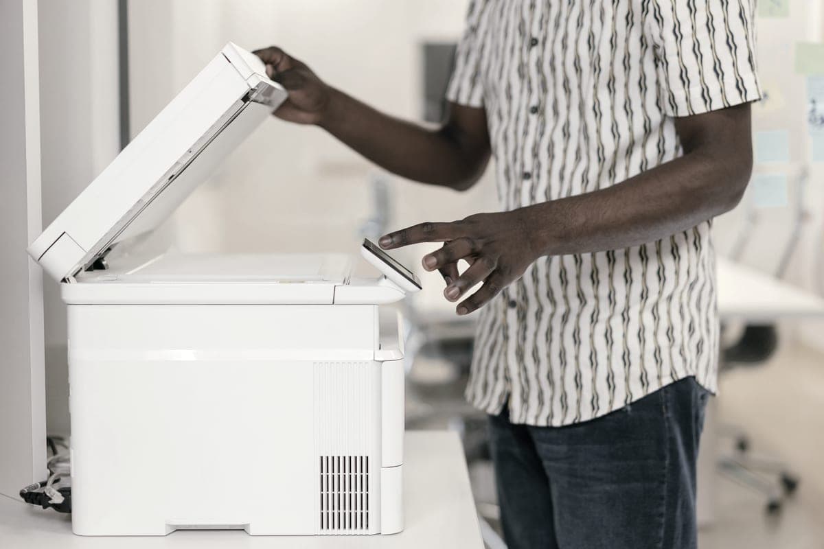 A person operating a multifunction printer and copier in an office