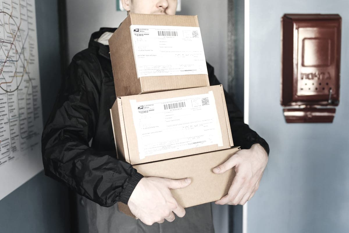 A delivery driver carrying parcels with printed shipping labels