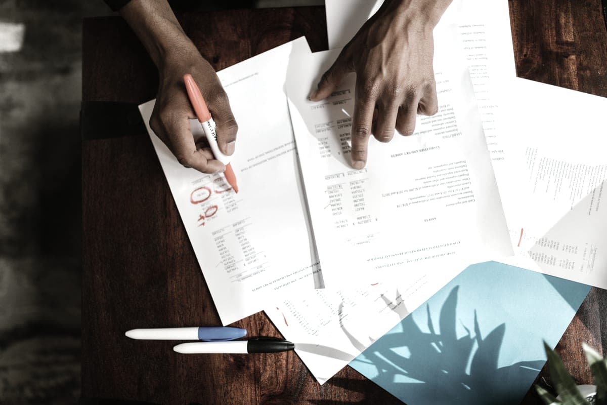 A person sorting through printed documents at a desk