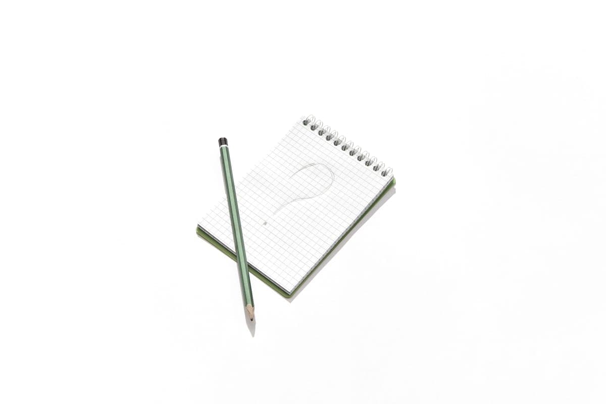 A notepad with a question mark drawn on it